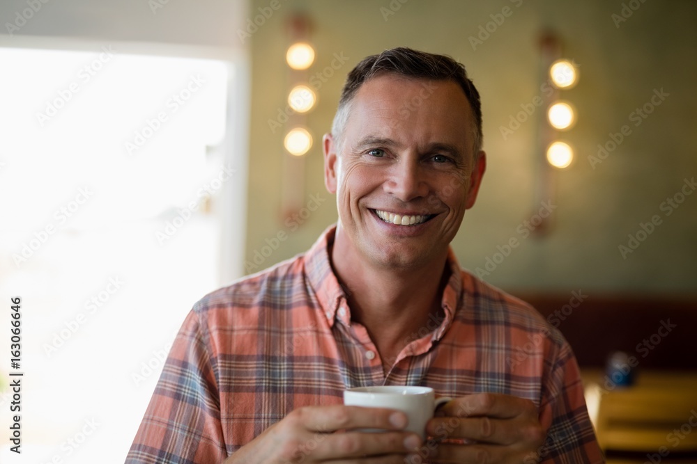 Smiling man having cup of coffee in restaurant Smiling man having cup of coffee in restaurant
