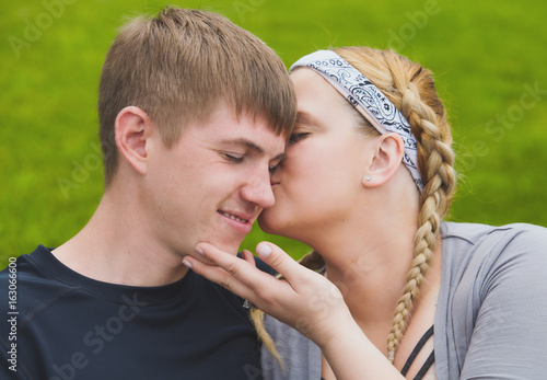 Portrait of happy woman kissing her boyfriend