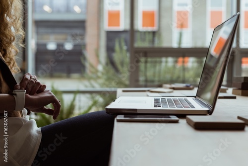 Female executive using smartwatch at desk photo