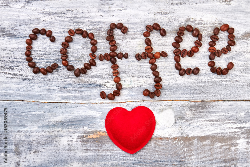 Fototapeta premium Word coffee from grain. Fabric heart on wooden background. With love for gourmet.