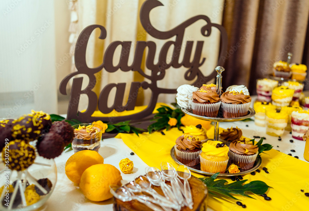 Holiday candy bar. Candy bar served with cupcakes with chocolate and lemon cream on stump Holiday candy bar. Candy bar served with cupcakes with chocolate and lemon cream on stump