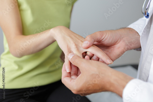 doctor checking patient with hand rheumatism