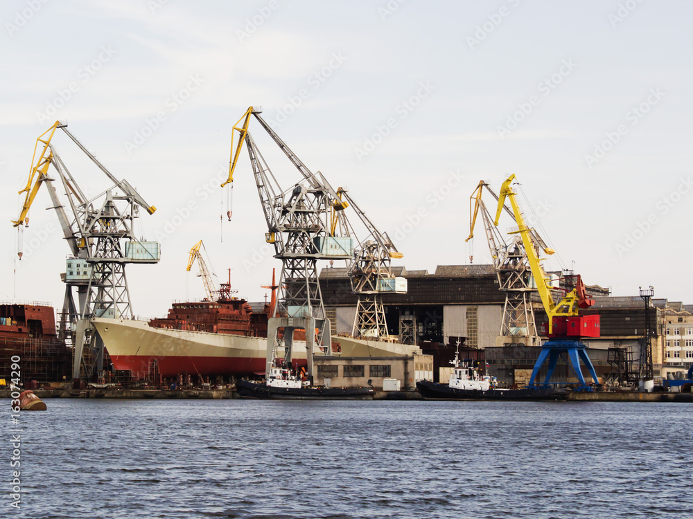 Big ship under repairing on floating dry dock in shipyard