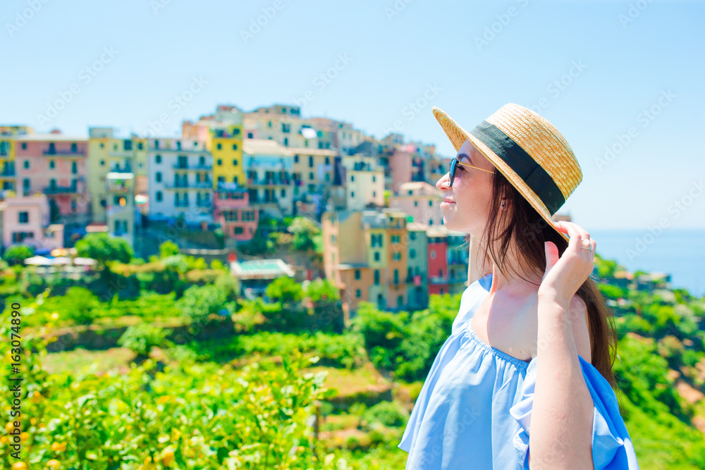 Young woman with beautiful view at old village in Cinque Terre, Liguria, Italy. European italian vacation.