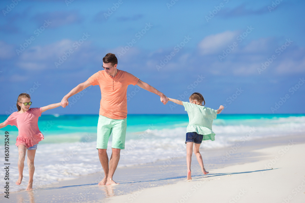 Family of dad and kids having fun on the beach