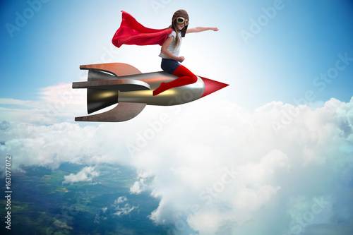 Little girl flying rocket in superhero concept © Elnur