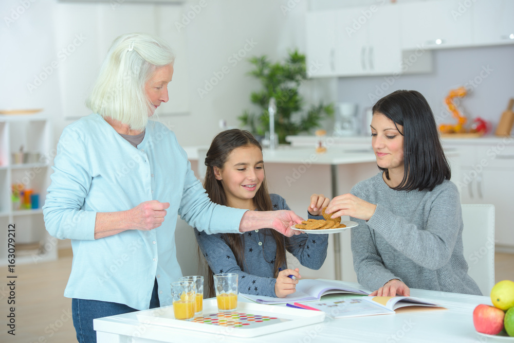 girl with mother and grandmother eating creps at home girl with mother and grandmother eating creps at home