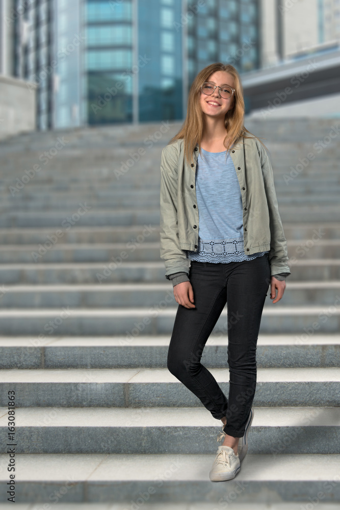 the young girl the blonde wearing spectacles stands on step the young girl the blonde wearing spectacles stands on step