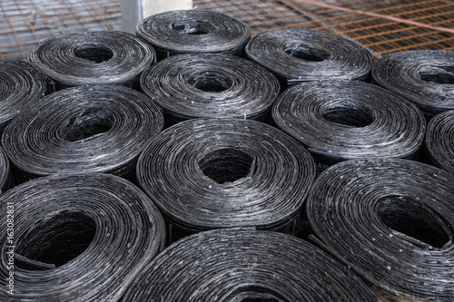 Black bituminous membrane sheet rolls stacked on a palette