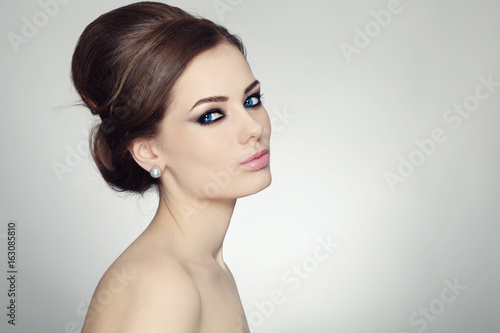Young beautiful woman with stylish make-up and hair bun