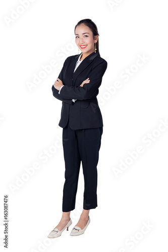 Smiling business woman black suit dressed standing against white background with crossed arms. Copy space.
