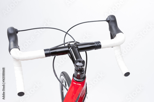 Bicycle Concept. Partial View of Professional Carbon Road Bike Handlebars With White Grip Tape. Against White.