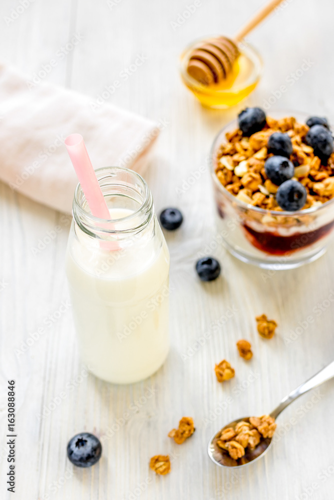 Fitness breakfast with granola, milk and honey on white backgrou Fitness breakfast with granola, milk and honey on white backgrou