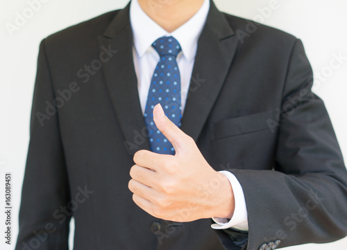 Young business man showing thumbs up over white background. Business success concept