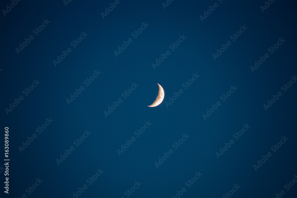 A young moon on a clear blue sky, in the darkness of darkness A young moon on a clear blue sky, in the darkness of darkness