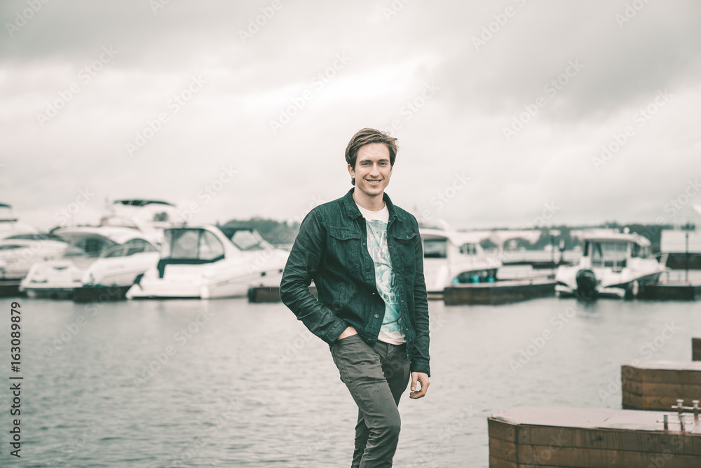 A man on the river bank in a yacht club