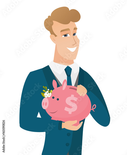 Caucasian groom holding a piggy bank.