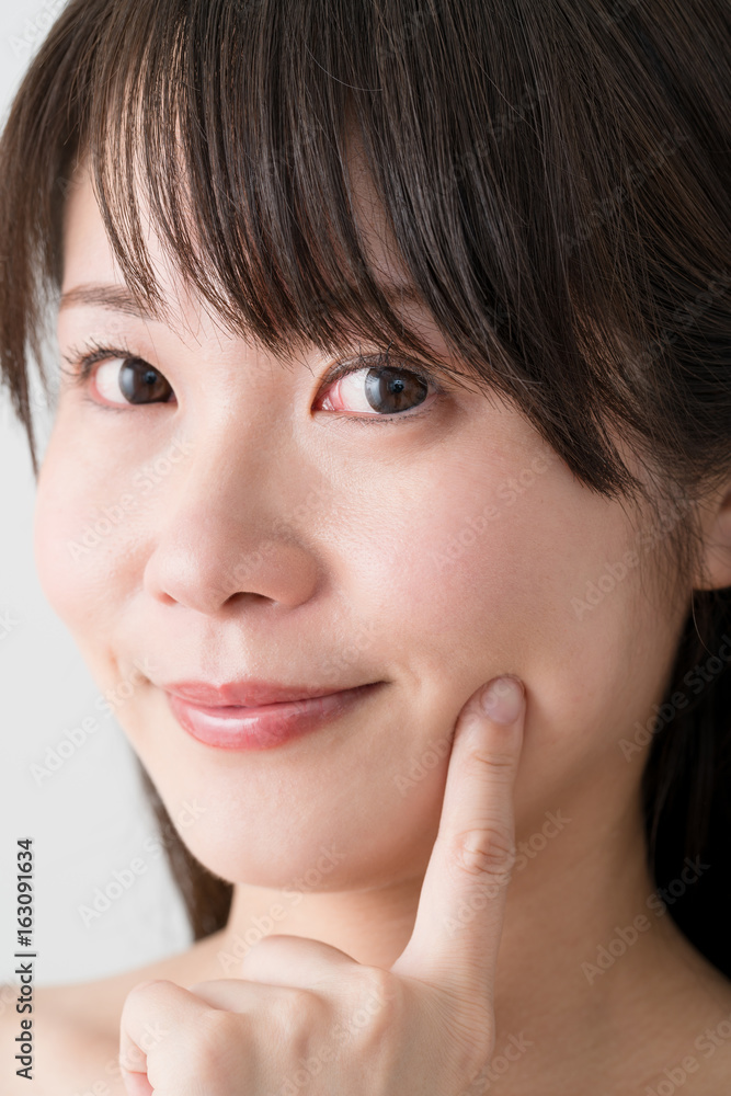 スキンケアをする女性、指を当てる スキンケアをする女性、指を当てる