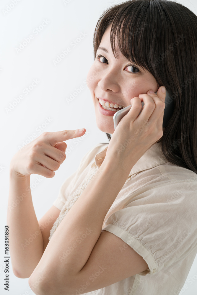 電話をする若い女性、喜ぶ、指差し 電話をする若い女性、喜ぶ、指差し