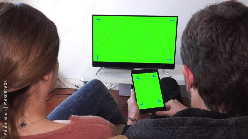 Video „Man And Woman At Home Watching Green Screen TV And Tablet, Zoom