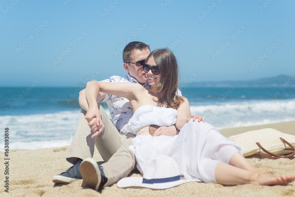 Young romantic couple sitting on the beach Young romantic couple sitting on the beach