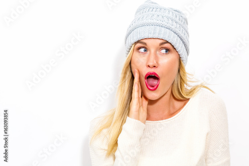 Happy young woman in winter clothes on a white background