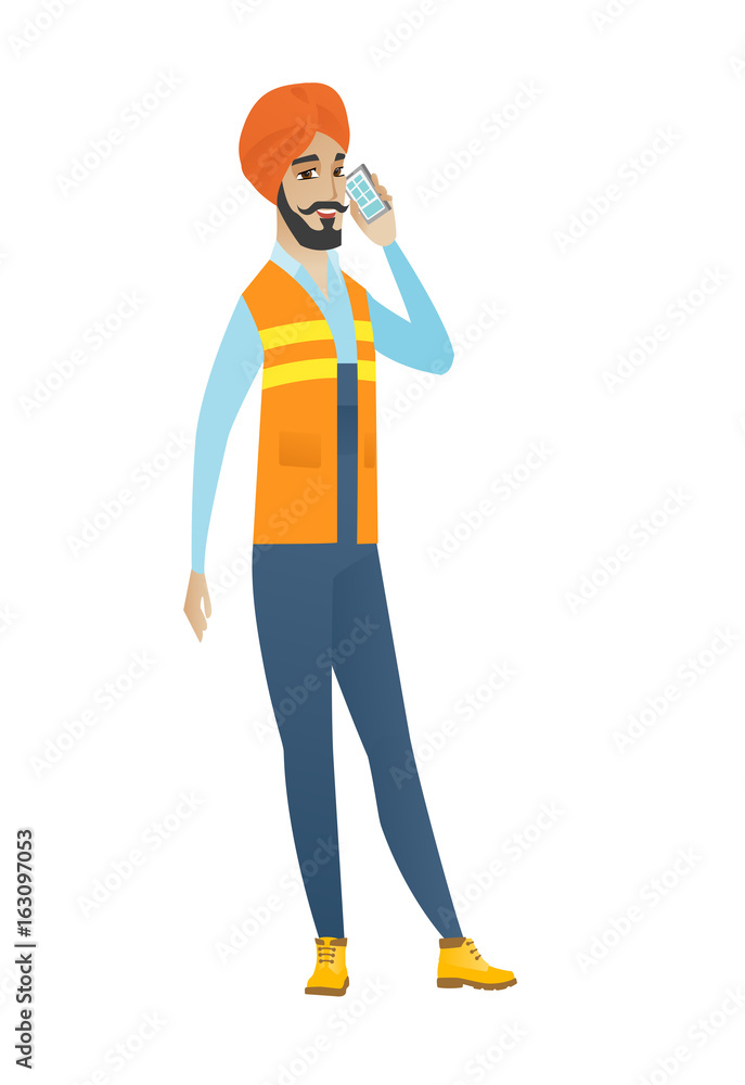 Young hindu builder talking on a mobile phone. Young hindu builder talking on a mobile phone.