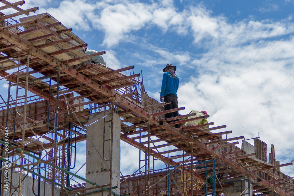 Naklejka premium Workers at the construction site and the sky