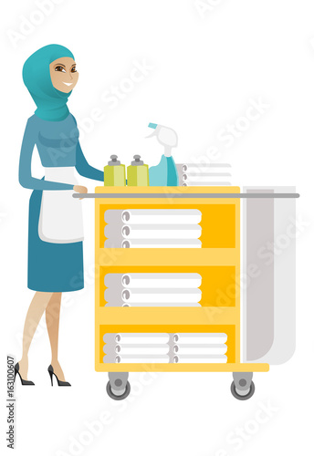 Muslim chambermaid pushing cart with bed clothes.