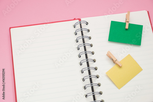 post it note with wooden clip stick isolated blank notebook. have pink on background. image for business,accessory,equipment,education,abstract concept