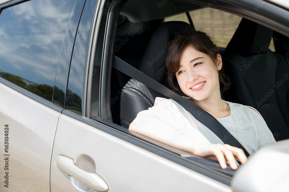 young woman sitting on assistant seat of motor vehicle.