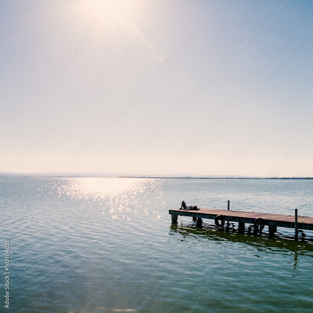 Fototapeta premium Relaxing girl on a pier