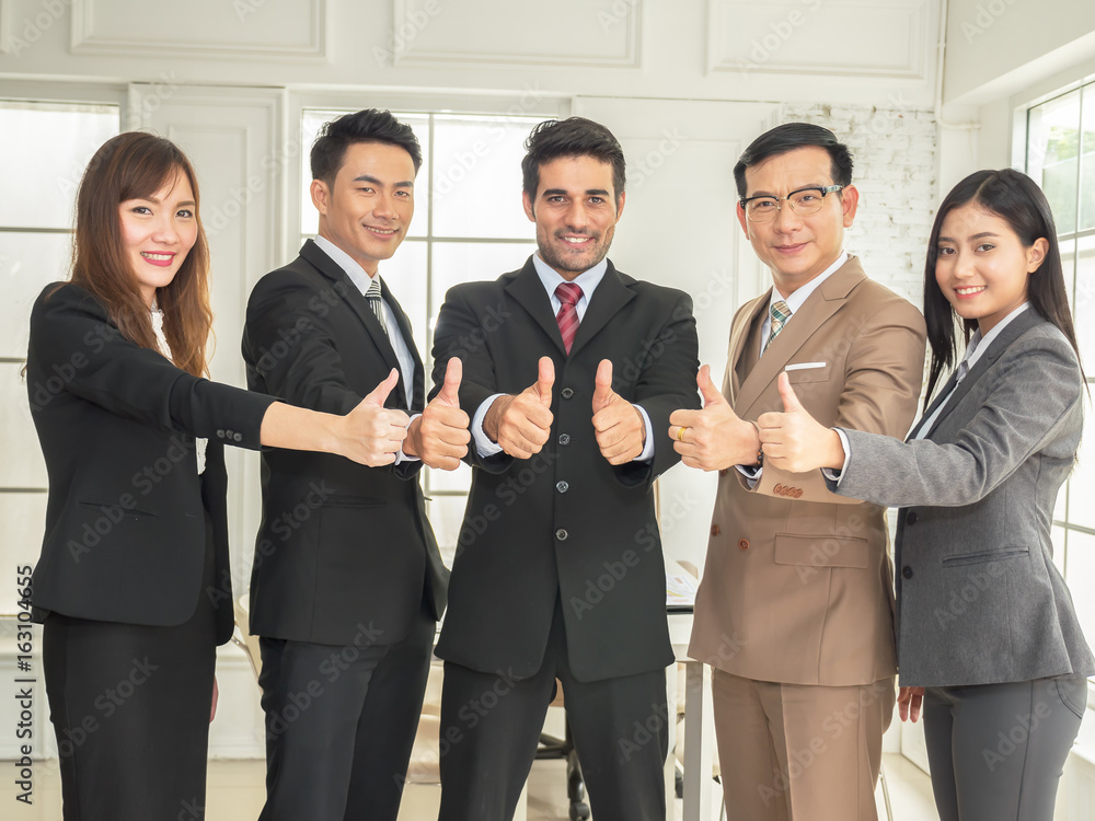 Group of businessman and businesswomen show thumb up as a successful sign Group of businessman and businesswomen show thumb up as a successful sign