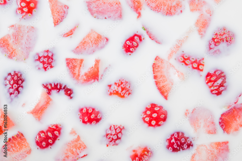 Background of a strawberry pieces in the milk. Sweet dessert. Healthy eating. Background of a strawberry pieces in the milk. Sweet dessert. Healthy eating.