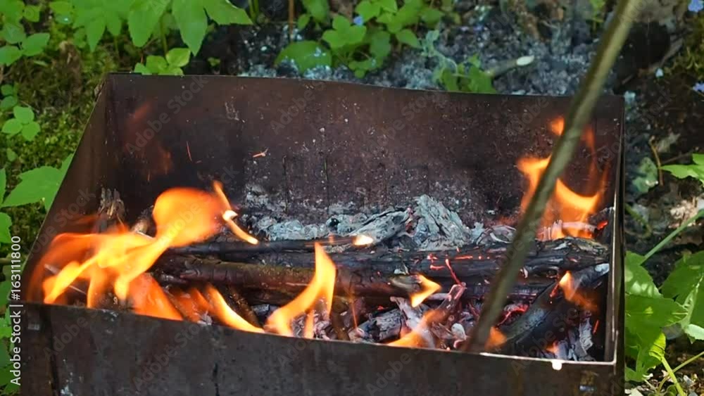 Brazier marching with fire during a halt on the nature. Tourist food in the woods for a picnic. Hiking in the wild. Brazier marching with fire during a halt on the nature. Tourist food in the woods for a picnic. Hiking in the wild.