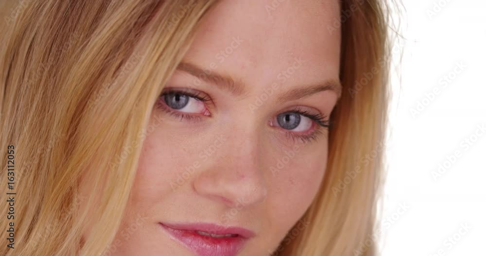 Close-up portrait of pretty blonde woman with blue eyes on white backdrop Close-up portrait of pretty blonde woman with blue eyes on white backdrop