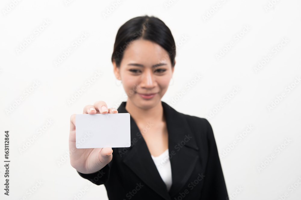 Portrait of young smiling asian business woman holding empty credit card isolated on gray background Portrait of young smiling asian business woman holding empty credit card isolated on gray background