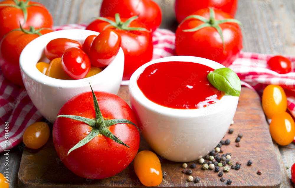 Ketchup with tomatoes on wooden background Ketchup with tomatoes on wooden background
