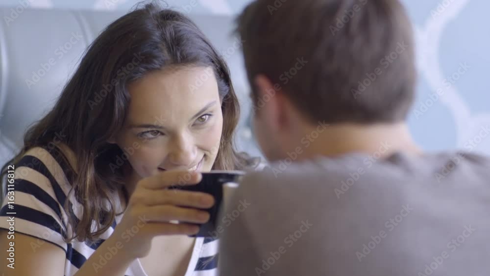 Cute Multiracial Couple Flirt At Coffee Shop, They Cheers And Laugh Cute Multiracial Couple Flirt At Coffee Shop, They Cheers And Laugh