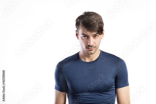 Handsome fitness man in blue t-shirt, studio shot.