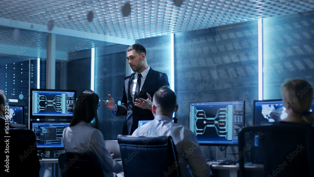 Supervisor Holds Briefing for His Employees in System Control Center Full of Monitors and Servers. Possibly Government Agency Conducts Investigation. Supervisor Holds Briefing for His Employees in System Control Center Full of Monitors and Servers. Possibly Government Agency Conducts Investigation.