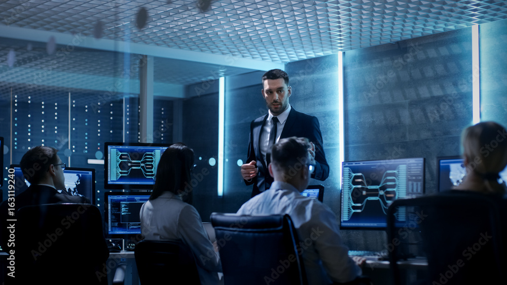 Supervisor Holds Briefing for His Employees in System Control Center Full of Monitors and Servers. Possibly Government Agency Conducts Investigation. Supervisor Holds Briefing for His Employees in System Control Center Full of Monitors and Servers. Possibly Government Agency Conducts Investigation.