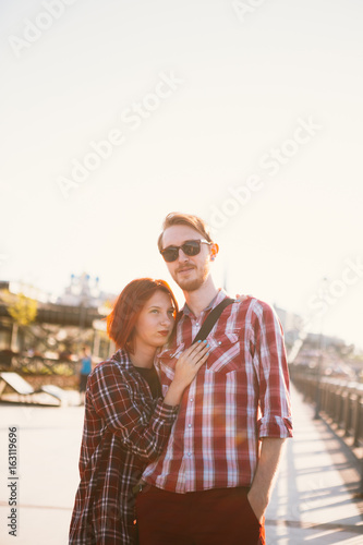 man and woman in the plaid shirt hugging on the background of the city
