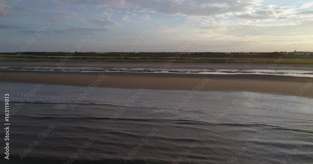 Sunset beach aerial view, flying over the sand and waves Slow Motion Sunset beach aerial view, flying over the sand and waves Slow Motion