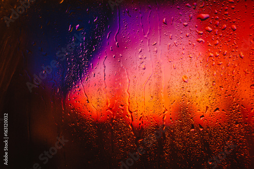 Raindrops on a wet window overlooking the city