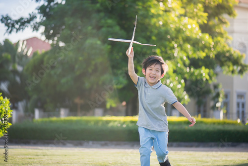 Asian child playing cardboard airplane