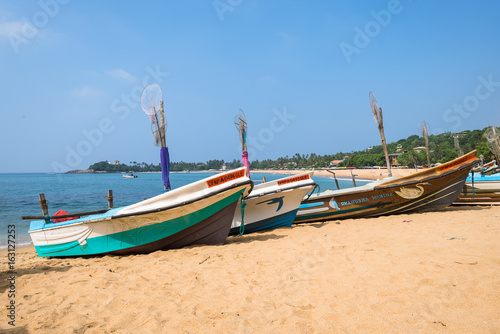 At the beach of Unawatuna  one of the major tourist spots in the south west of Sri Lank. Outrigger and traditional fishing boats on the beach