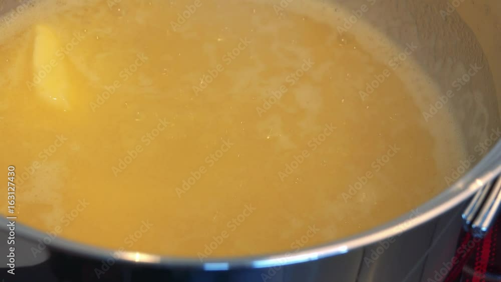 Butter in a steel bowl is almost completely melted - closeup Butter in a steel bowl is almost completely melted - closeup