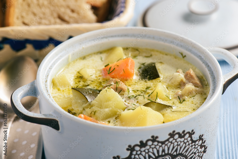 Potato soup with turkey and zucchini in blue kitchen pot. Potato soup with turkey and zucchini in blue kitchen pot.