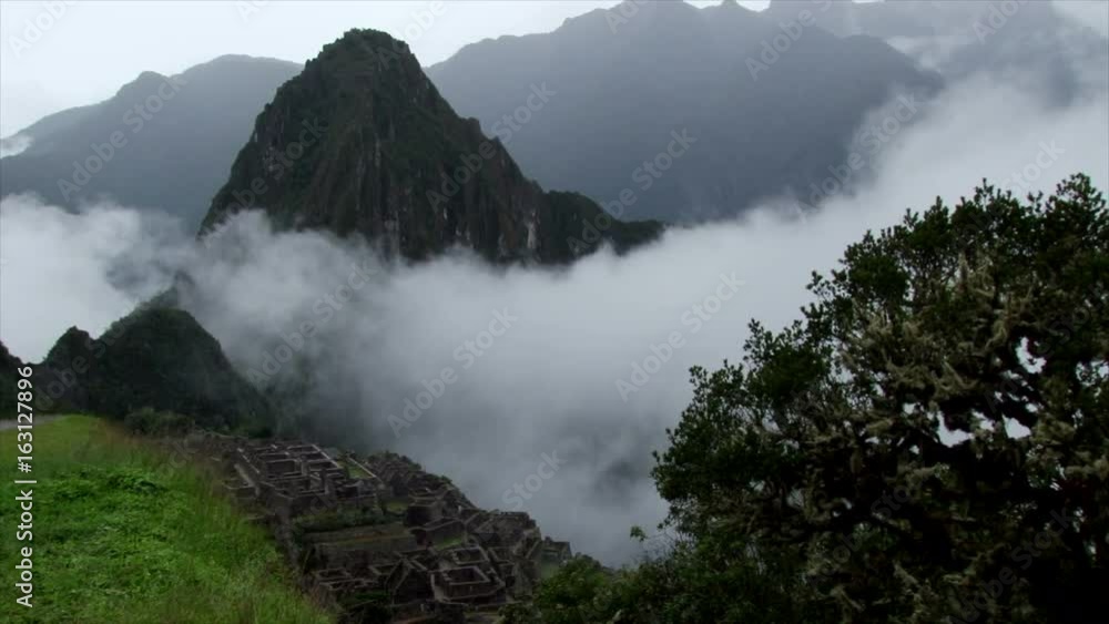Wide shot of clouds rolling over Machu Picchu the ancient Inca ruins in the Peruvian Andes Wide shot of clouds rolling over Machu Picchu the ancient Inca ruins in the Peruvian Andes